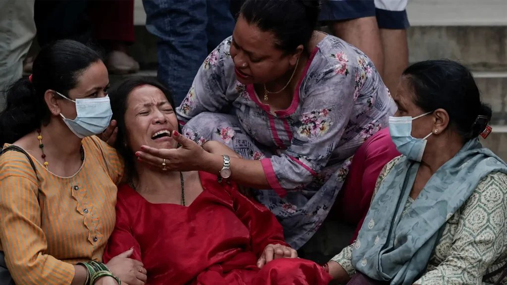 Family members of Nepal plane crash victims grieving outside a hospital in Kathmandu, showcasing the emotional aftermath of the tragedy, covered by Malaysia news.